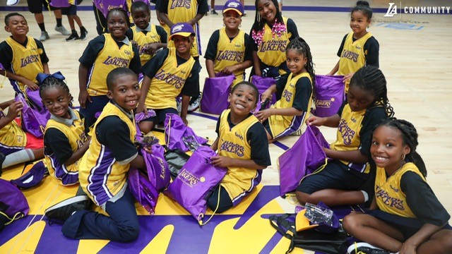 Children in Lakers gear on the court